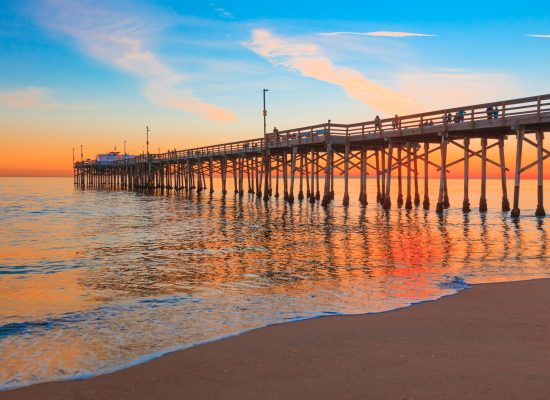 Incoming tide reflects the sunsent at Balboa Pier in Newport Beach, CA